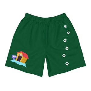 May include: Green athletic shorts with a cartoon dog house with the word "Pluto" on it. The shorts have a row of white paw prints down the right leg.
