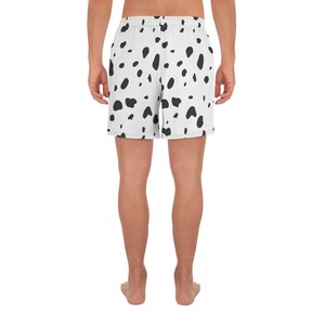 May include: White athletic shorts with a black dalmatian spot pattern. The shorts have an elastic waistband and are made of a lightweight material. The shorts are knee-length.