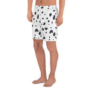May include: White athletic shorts with a black spot pattern. The shorts have an elastic waistband and a relaxed fit. The design resembles a Dalmatian dog's coat. These shorts are suitable for various activities.