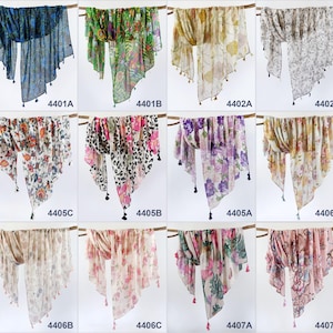 Puede incluir: Diez bufandas de diferentes patrones con borlas. Las bufandas son de varios colores y patrones, incluyendo floral, estampado de animales y geom&eacute;trico.