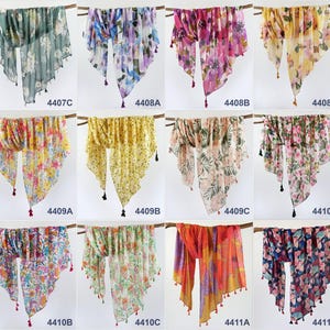 Puede incluir: Diez bufandas diferentes con patrones florales y borlas. Las bufandas son de varios colores, incluyendo azul, verde, rosa, amarillo y rojo.