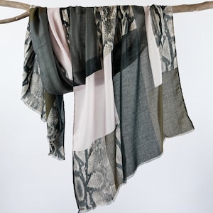 Peut inclure: Une écharpe multicolore avec un motif peau de serpent. L'écharpe est faite d'un tissu doux et léger, parfait pour ajouter une touche de style à n'importe quelle tenue.