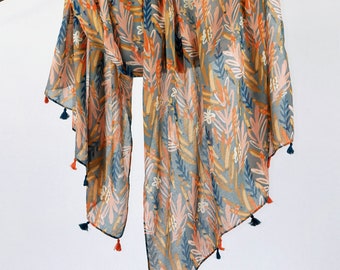 May include: A light blue and orange floral patterned scarf with tassels. The scarf is draped over a branch.
