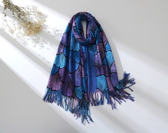May include: A blue and purple scarf with a leaf pattern and fringe. The scarf is folded in half and has a tassel on each end.