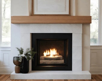 May include: A white marble fireplace with a black surround and a gas fireplace insert. The fireplace is lit and the flames are visible. The fireplace is in a modern home with white walls and a wooden mantel.