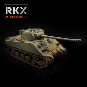 Może przedstawiać: Miniaturowy oliwkowy czołg z długą lufą, gąsienicami i obrotową wieżą. Model ma postarzany wygląd, sugerujący, że jest repliką historycznego pojazdu wojskowego. Widoczny jest tekst "RKY MINIATURES".