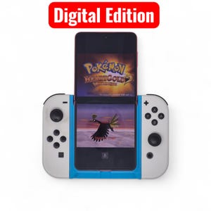 May include: A smartphone displaying a video game, held in a white and blue game controller grip. The game screen shows a Pokemon game. The words "Digital Edition" are in a red rectangle at the top.
