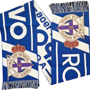 Puede incluir: Bufanda azul y blanca con el texto "REAL CLUB DEPORTIVO LA CORUÑA" y un emblema del equipo. La bufanda tiene un patrón de rayas y flecos en los extremos. El emblema del equipo incluye una corona y una cruz morada.
