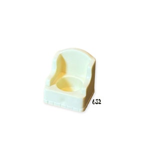 May include: A white plastic potty chair with a rounded seat and a back. The chair has a textured surface and a number "632" printed on the side.