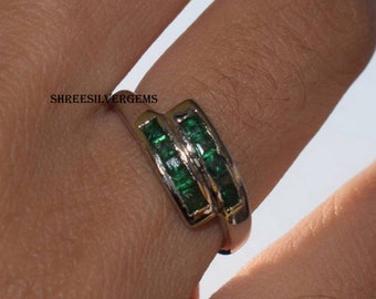May include: A silver ring with two rows of emerald green baguette-cut gemstones. The ring is set in a silver band with a polished finish. The text "SHREESILVERGEMS" is visible in the image.
