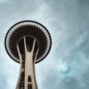 May include: A low angle view of the Space Needle in Seattle, Washington. The iconic tower is a popular tourist destination and offers stunning views of the city.