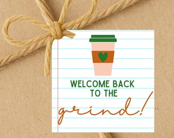 May include: A gift tag with a coffee cup graphic and the text "WELCOME BACK TO THE grind!" is tied with twine. The coffee cup is pink with a green lid, a brown sleeve, and a green heart.
