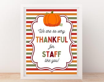 May include: A framed print with a white border. The print features a pumpkin illustration above the text "We are so very THANKFUL for STAFF like you!" The background has horizontal stripes in red, orange, and green.