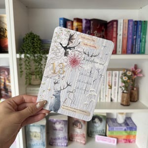 May include: A rectangular card featuring a collage of illustrations including a large number 13, a deer, a dragon, a red heart, and various floral motifs. The card contains text snippets such as hello, princeling, hello, witchling, and fireheart.