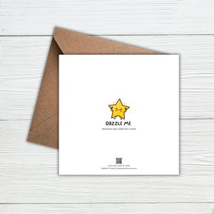 May include: A square white greeting card with a brown envelope. The card features a yellow star character with a smiling face, the text DAZZLE ME PERSONALISED GREETING CARDS, a small QR code, and the text SCAN QR CODE TO SHOP WEBSITE | thedazzleme.etsy.com.