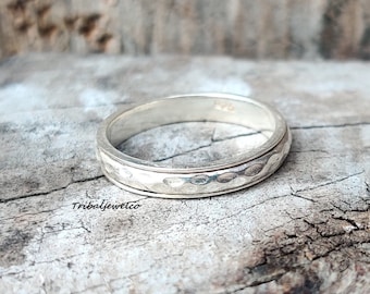 May include: A silver ring with a hammered texture. The ring is simple and elegant, and would make a great gift for a special occasion.