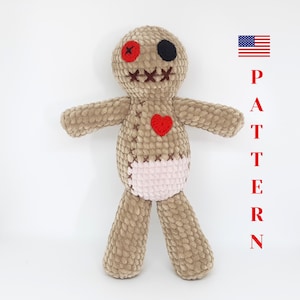 May include: A handmade, plush voodoo doll in tan, with a red heart, a red button eye, and a black button eye. The doll has a pink diaper-like section and stitched details. The word "PATTERN" is written vertically in red.