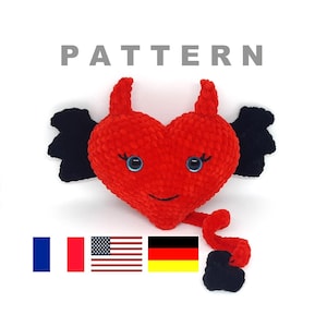 May include: Crochet pattern for a red heart-shaped amigurumi toy with black horns, wings, and tail. The toy has a smiling face with blue eyes. The pattern is available in French, English, and German.