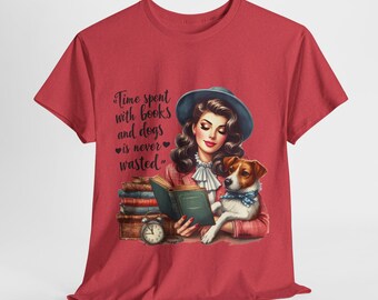 Puede incluir: Camiseta roja con un gráfico de una mujer leyendo un libro con un perro sentado a su lado. El texto en la camiseta dice "El tiempo pasado con libros y perros nunca se desperdicia."