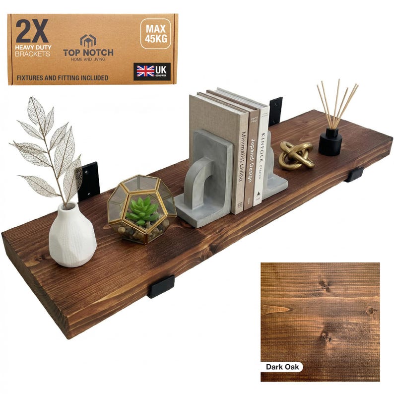 Dark oak floating shelf with black brackets, holding books, decorative items, and a small terrarium. The shelf is made of wood and includes a box of heavy-duty brackets. The shelf can hold up to 45 kg.