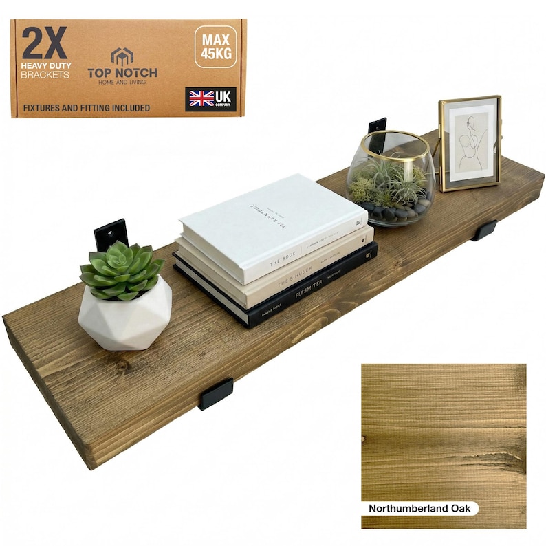 Northumberland Oak Stain wooden shelf, supported by black metal brackets, with a succulent, books, and a framed picture. The shelf can hold up to 45 kg. The packaging reads "2X Heavy Duty Brackets" and "UK Company".