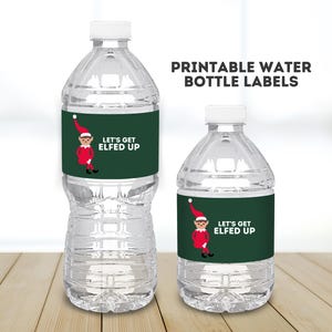 Könnte beinhalten: Zwei durchsichtige Plastikwasserflaschen mit grünen und roten Etiketten, auf denen "Let's Get Elfed Up" steht. Die Etiketten zeigen einen Cartoon-Elf mit roter Mütze und grünem Anzug.