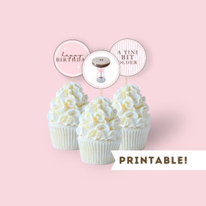 May include: Printable cupcake toppers with pink and white striped, pink and white polka dot, and a martini glass design. The text on the toppers reads "Happy Birthday" and "A Tini Bit Older".