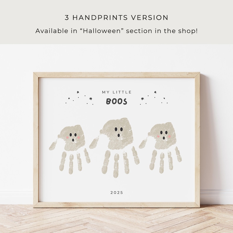 Puede incluir: Una impresi&oacute;n enmarcada con un marco de madera clara. La impresi&oacute;n presenta tres fantasmas de huellas de manos con el texto "MY LITTLE BOOS" y el a&ntilde;o 2025. La parte superior de la impresi&oacute;n tiene peque&ntilde;as ilustraciones de estrellas. El texto "3 HANDPRINTS VERSION" est&aacute; en la parte superior.