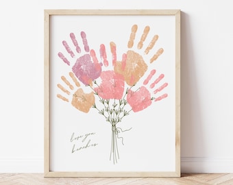 May include: A framed print with a handprint bouquet of flowers in pink, orange, and purple. The text "love you bunches" is written below the bouquet.
