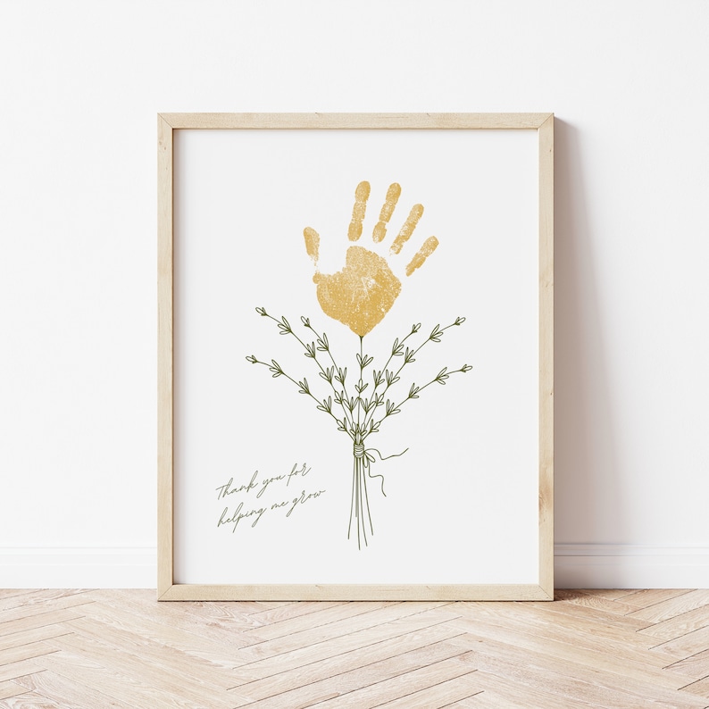 May include: A framed print with a gold handprint and green leaves, with the text "Thank you for helping me grow".