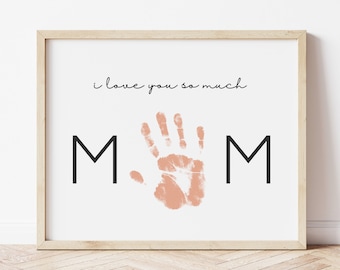 May include: A framed print with the words "i love you so much" and the word "MOM" with a pink handprint in the middle.