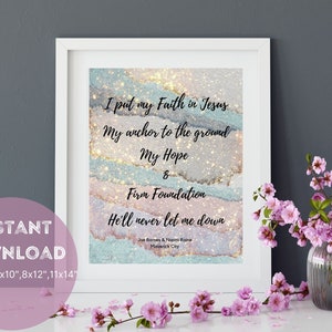 Puede incluir: Una descarga digital imprimible de una cita cristiana sobre la fe, la esperanza y una base firme. La cita se coloca sobre un fondo abstracto brillante en tonos de rosa, azul y dorado. El texto dice "Pongo mi fe en Jesús, Mi ancla en el suelo, Mi esperanza & Base firme, Nunca me dejará caer." La cita se atribuye a Joe Bomes & Noomi Raine, Maverick City.