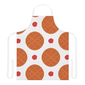 May include: A white apron featuring a repeating pattern of round, golden-brown lattice-crust pies and small, solid red apples. The apron includes a neck loop and two side ties, all in a matching white colour, providing a clean, uniform appearance.