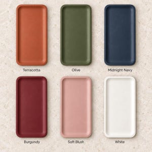 May include: Six rectangular trays arranged in two rows of three. The colors are labeled as Terracotta, Olive, Midnight Navy, Burgundy, Soft Blush, and White. Each tray features rounded corners and a smooth, solid-colored surface finish.