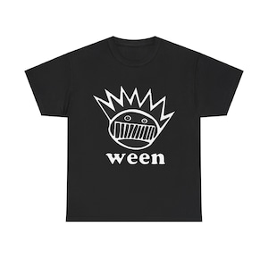 Puede incluir: Camiseta negra con un gráfico blanco de una cara de dibujos animados con una corona de púas y la palabra "ween" debajo.
