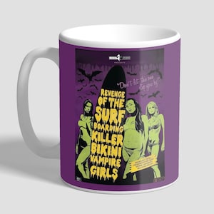 May include: A white ceramic mug with a purple background and a retro movie poster design. The poster features three women in green bikini tops and shorts, riding a surfboard with the text "Revenge of the Surf Boarding Killer Bikini Vampire Girls".