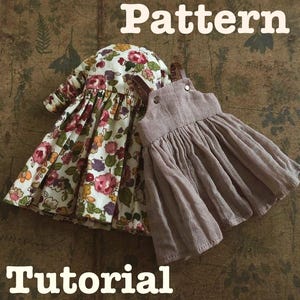 Könnte beinhalten: Zwei Puppenkleider. Eines hat ein Blumenmuster mit rosa, roten und gelben Blumen auf weißem Grund. Das andere Kleid ist einfarbig mauve. Die Wörter "Pattern" und "Tutorial" sind zu sehen. Die Kleider sind aus Stoff.