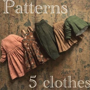 May include: An assortment of five miniature clothing items in various colors. The collection includes a peach-colored dress, a brown floral dress, green pants, a tan skirt, and a green jacket. The word "Patterns" is at the top, and "5 clothes" is at the bottom.