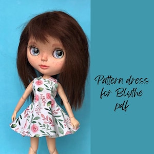 May include: A doll with brown hair and blue eyes wearing a white dress with a floral pattern of pink roses and green leaves. The text "Pattern dress for Blythe pdf" is written in black cursive on a teal background.