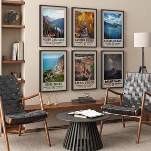 May include: Six framed vertical wall art prints featuring landscape photography of North Cascades, Eastern Sierra, Crater Lake, Big Sur, Mesa Verde, and the Milky Way at Yosemite, each with bold text labels and a cream-colored border in black frames.