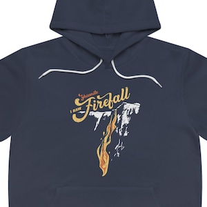 May include: A navy blue hoodie with a white drawstring. The hoodie features a graphic of a waterfall with flames and the text "I saw Yosemite Firefall".