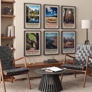 Puede incluir: Una colecci&oacute;n de carteles enmarcados con paisajes de parques nacionales, incluyendo Yosemite, Yellowstone y Grand Canyon. Los carteles se exhiben en una pared beige sobre una estanter&iacute;a de madera. Dos sillas negras tejidas y una mesa redonda negra est&aacute;n en primer plano.