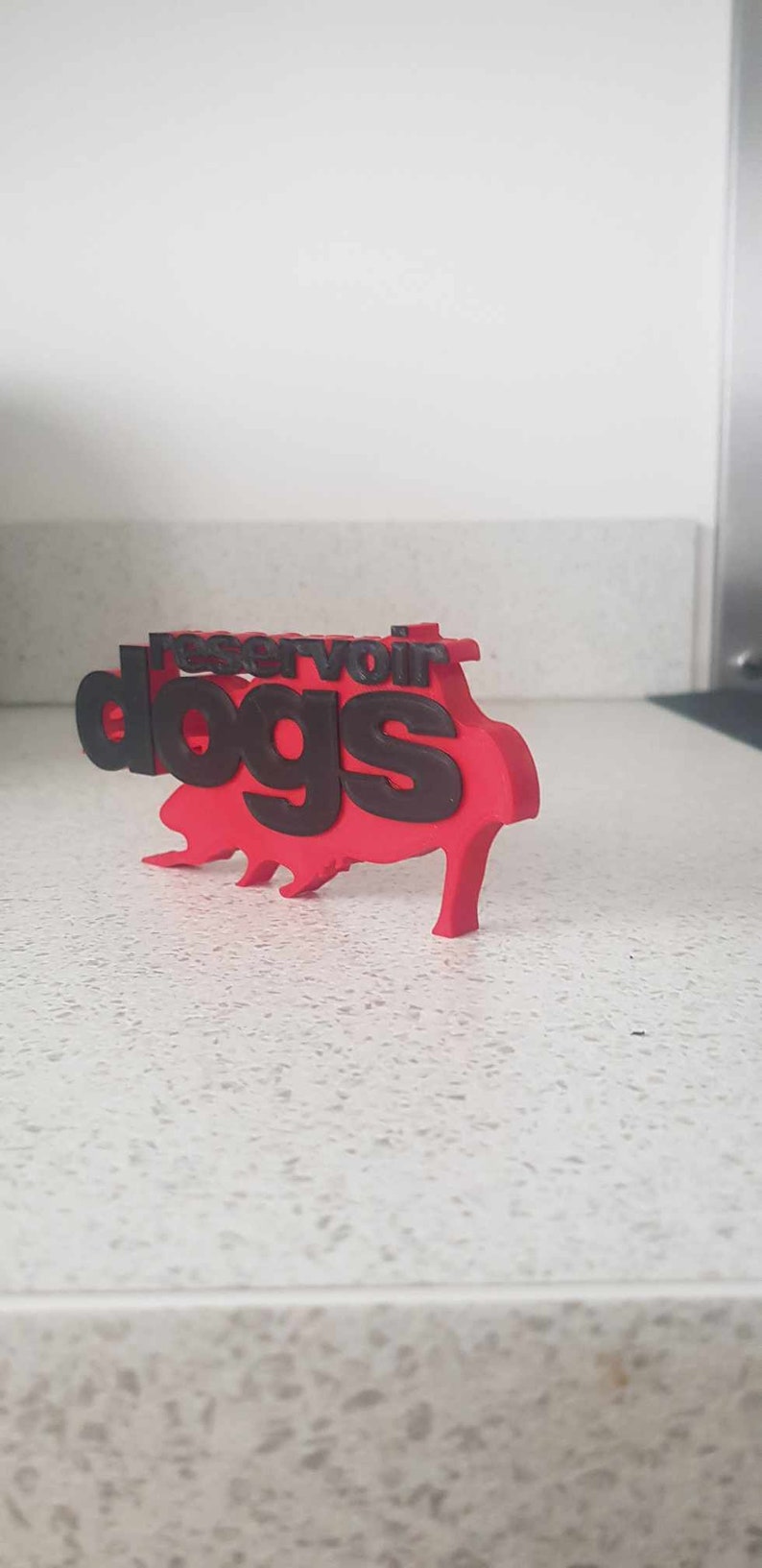 Op de afbeelding: Een rood 3D-geprint model van de filmtitel "Reservoir Dogs" met zwarte letters.