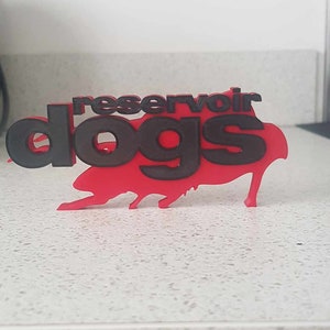 Op de afbeelding: Een rood en zwart 3D-geprint bord met de tekst "Reservoir Dogs".