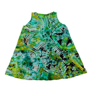 Pode incluir: Um vestido sem mangas com um padrão tie-dye em tons de verde, azul e amarelo.