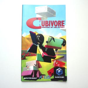 May include: A rectangular instruction booklet for the video game Cubivore: Survival of the Fittest for Nintendo GameCube. The cover features a colorful, blocky creature illustration, the game title in red text, and the Atlus and GameCube logos.