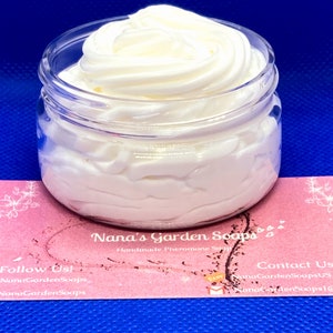 May include: A white, whipped body butter in a clear glass jar with a pink and white label that reads "Nana's Garden Soaps Handmade Pheromone Soaps". The label also includes the text "Follow Us! NanaGardenSoaps NanaGardenSoaps" and "Contact Us NanaGardenSoapsUS NanaGardenSoaps!"