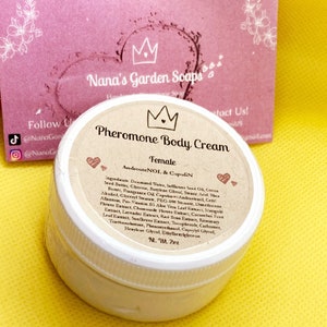 May include: A white jar with a gold crown and the text "Pheromone Body Cream Female AndrosteNOL & CopuliN" on the label. The jar is sitting on a yellow surface.