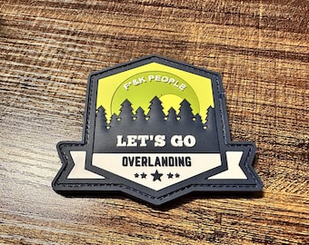 May include: A navy blue and white patch with the text "LET'S GO OVERLANDING" and the words "F&K PEOPLE" in a yellow and green background. The patch features a forest silhouette and three stars.