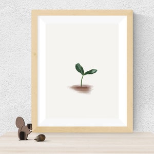 Op de afbeelding: Een ingelijste print van een eenvoudige groene plant met twee bladeren die uit de grond groeien. De print is in een licht houten lijst.